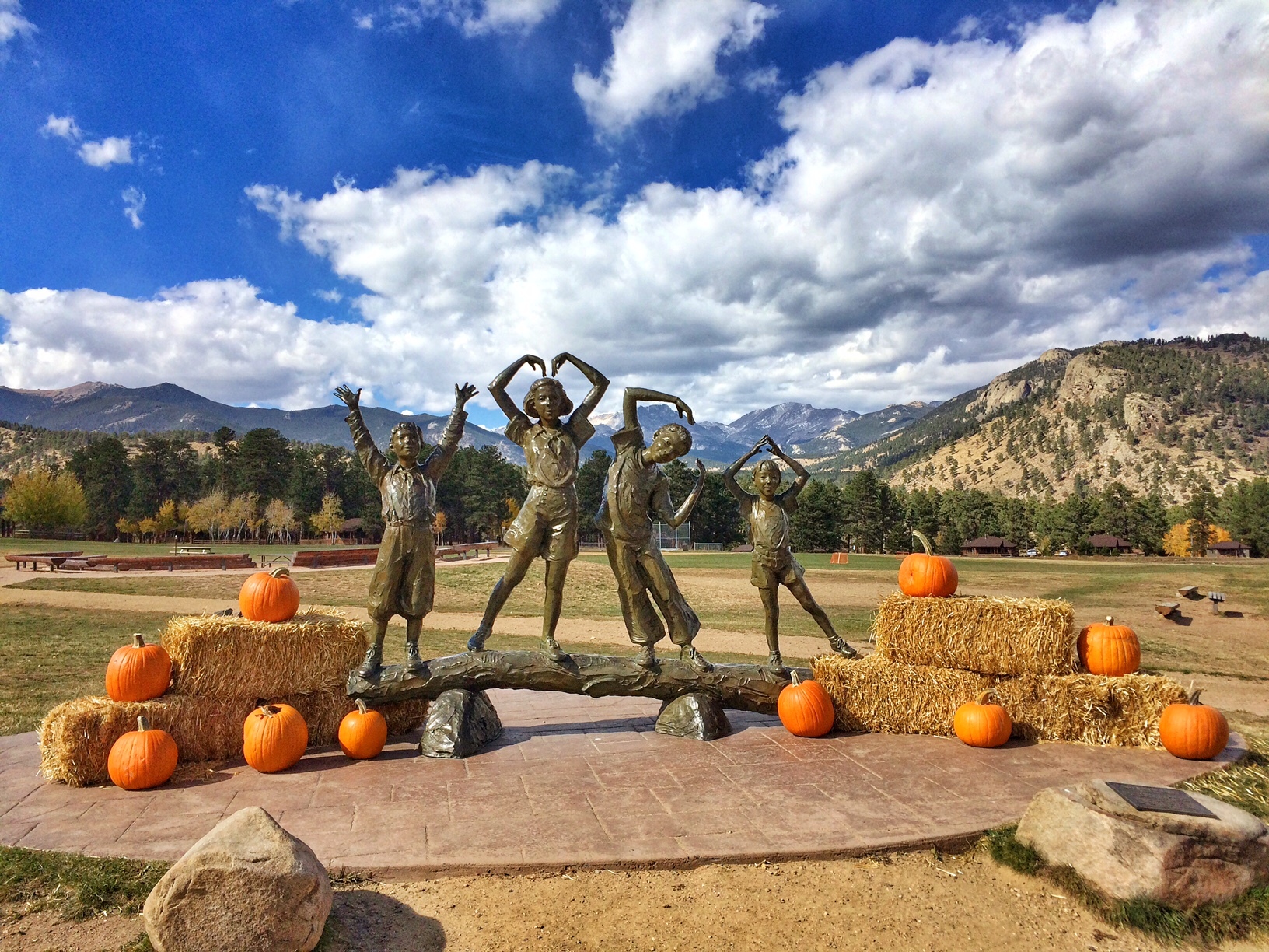 Photo of a statue surrounded by pumpkins